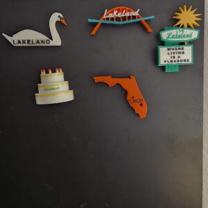 Lakeland, FL souvenir magnets featuring the iconic features of Lakeland including the Southgate Shopping Center arch, swan, birthday cake tower, dry cleaners sign and a state of Florida magnet featuring the location of Lakeland on the map.