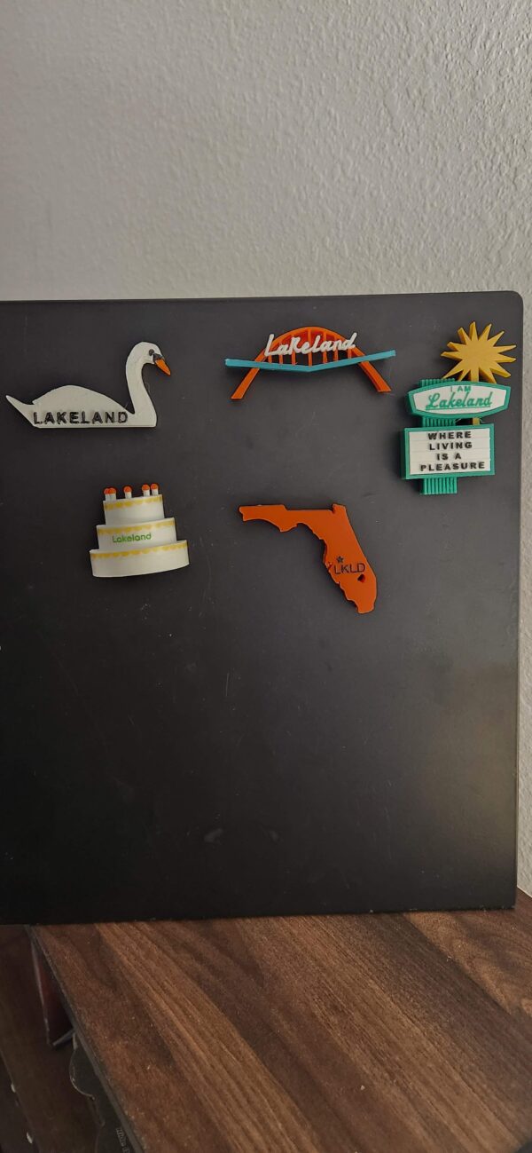 Lakeland, FL souvenir magnets featuring the iconic features of Lakeland including the Southgate Shopping Center arch, swan, birthday cake tower, dry cleaners sign and a state of Florida magnet featuring the location of Lakeland on the map.