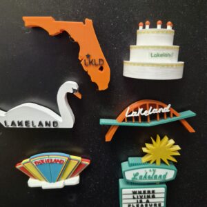 Lakeland, FL souvenir magnets featuring the iconic features of Lakeland including the Southgate Shopping Center arch, swan, birthday cake tower, dry cleaners sign and a state of Florida magnet featuring the location of Lakeland on the map.