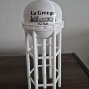 3D printed miniature replica of the La Grange, Kentucky water tower featuring a white elevated tank with locomotive artwork, "La Grange" lettering, and detailed support legs, inspired by the city's historic railroad heritage.