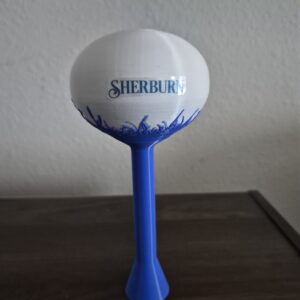 3D printed Sherburn, Minnesota water tower replica with blue fox, prairie grass and bird design on a white tank and blue support column.