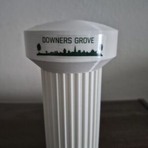 Downers Grove Illinois water tower replica with white elevated tank, fluted pedestal, and Downers Grove skyline logo.