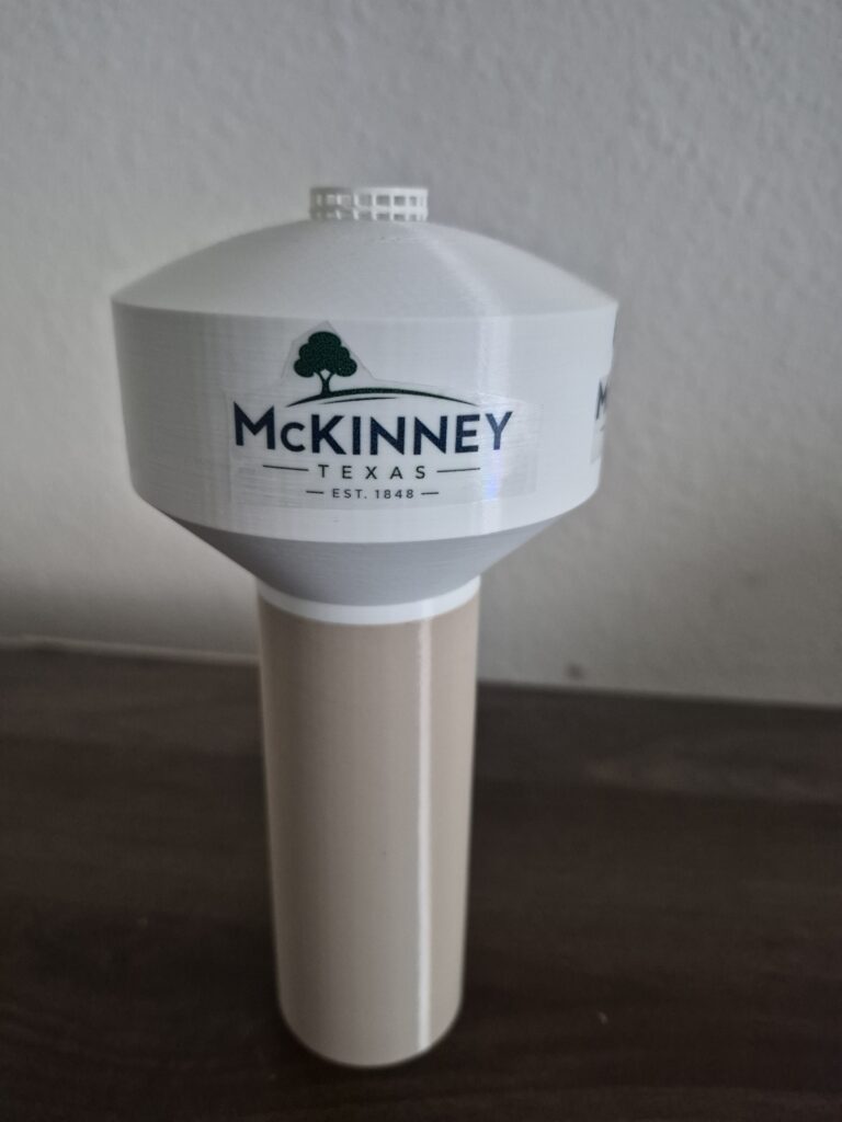 replica of the McKinney, Texas water tower featuring a stylized interpretation of the city's branding.