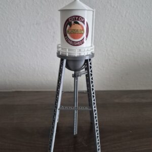 replica of the historic Groveland, Florida water tower with white cylindrical tank, orange city graphic, railing, and silver-gray support structure.