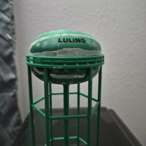 replica of the Luling, Texas watermelon water tower featuring a green elevated structure and hand-painted watermelon pattern